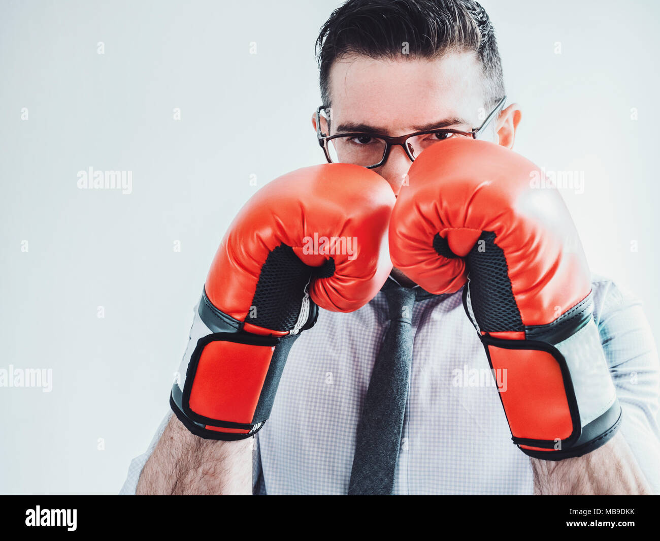 Jeune homme, brutal, dans les verres, cravate et gants de boxe rouge sur un  fond blanc. Lutte, d'affaires, le succès, l'argent Photo Stock - Alamy