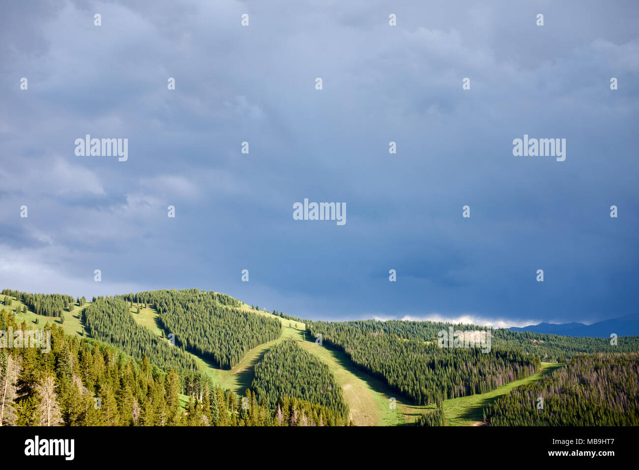 Paysage vallonné avec le vert des montagnes contre les sombres nuages Banque D'Images