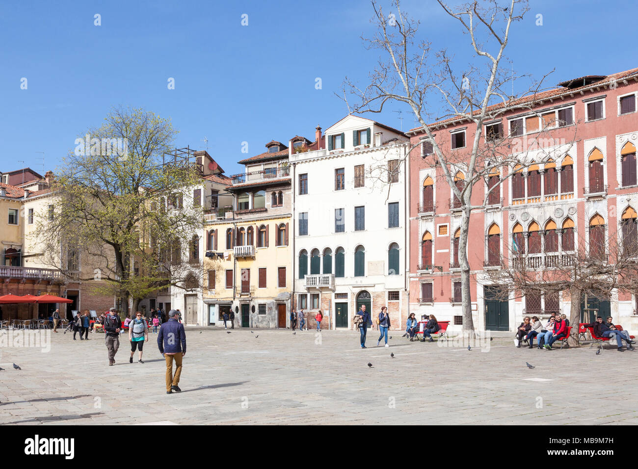 Campo San Polo, San Polo, Venise, Vénétie, Italie au printemps avec les  habitants et les touristes de vous détendre sur les bancs et traverser la  place en face du palais Photo Stock -