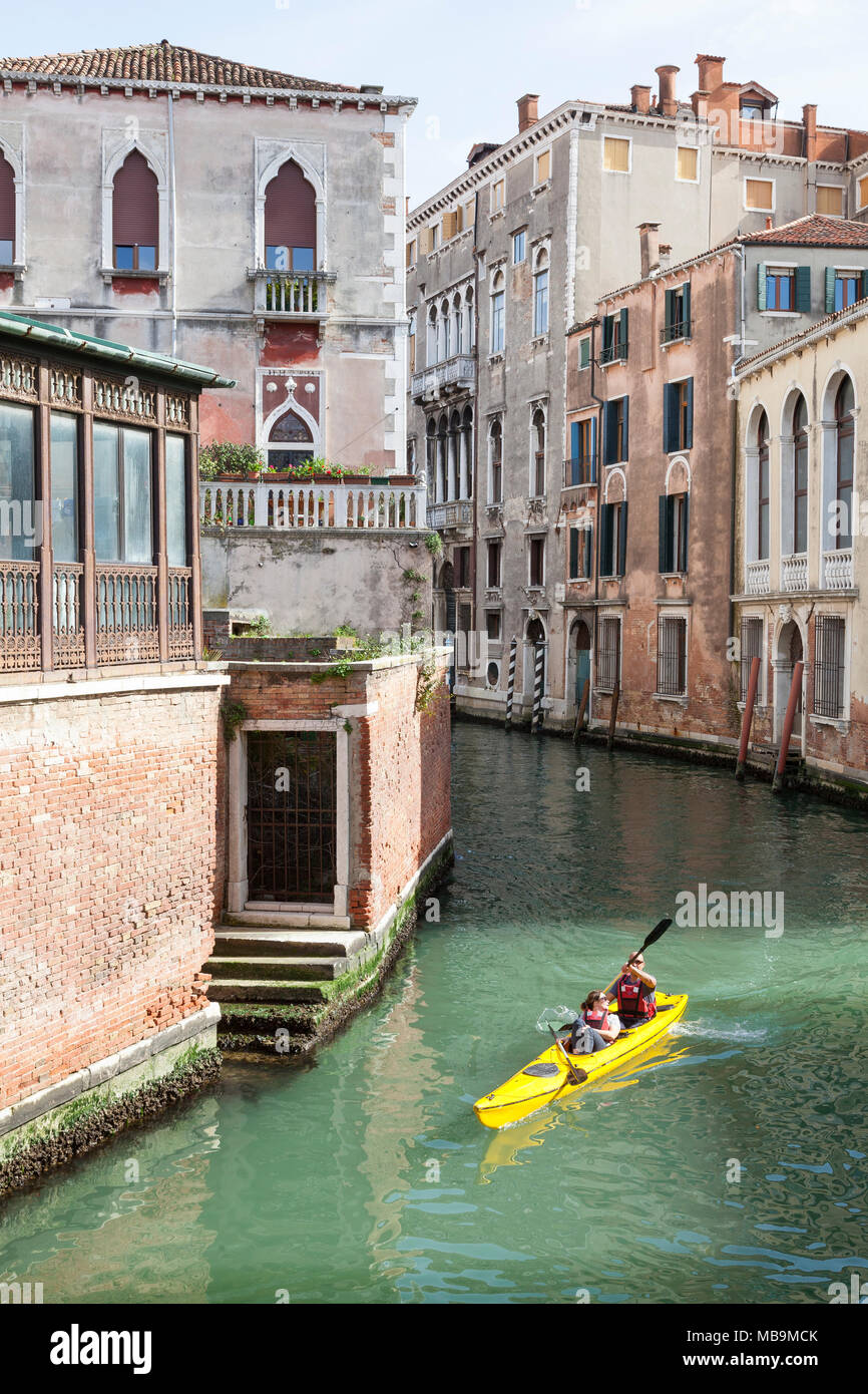 Couple de touristes kayak sur le Rio San Polo, San Polo, Venise, Vénétie Italie dans un kayak de location qu'ils profiter de visites l'arrière de la ville de canaux Banque D'Images