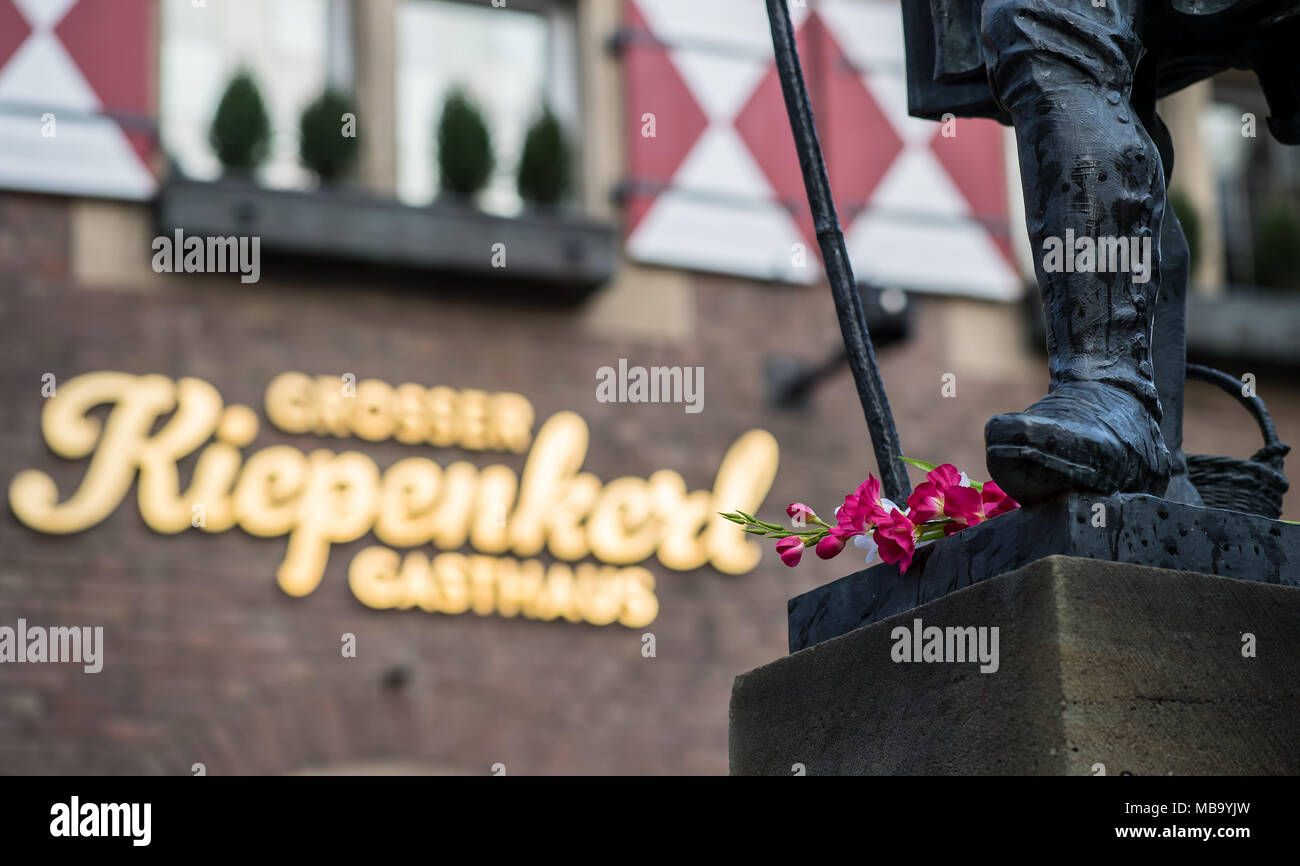 Münster, Allemagne. 09 avril 2018, l'Allemagne, Münster : une fleur se trouve au pied de la 'Kiepenkerl' statue devant le restaurant du même nom. C'est l'une des nombreuses fleurs et de bougies se trouvant sur le site d'une attaque de van qui s'est produit le 07 avril. Un homme conduit un van dans un groupe de clients assis à l'extérieur du restaurant 'Kiepenkerl' et s'est tiré par la suite. Photo : Guido Kirchner/dpa dpa : Crédit photo alliance/Alamy Live News Banque D'Images