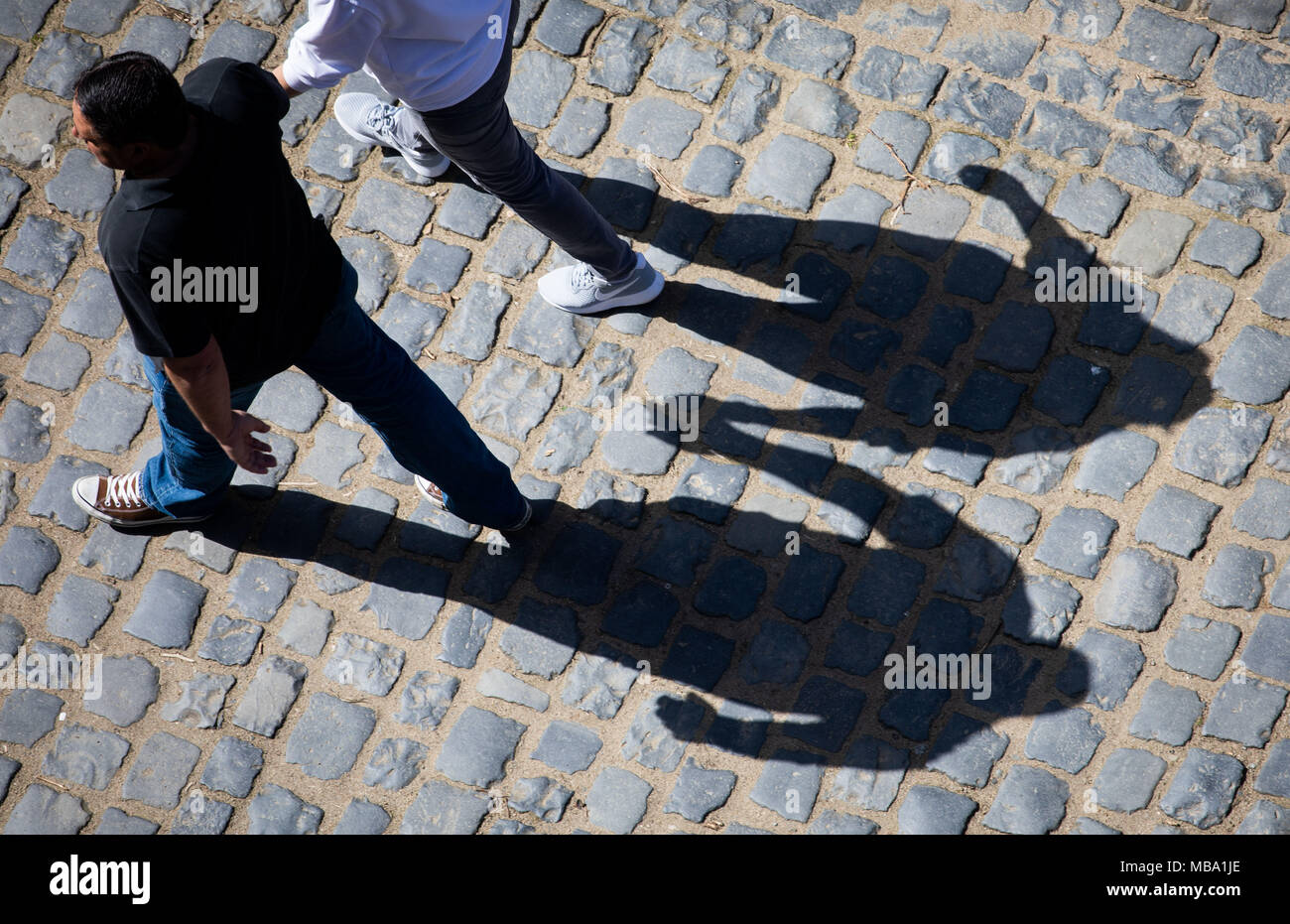 08 avril 2018, l'Allemagne, Bensheim : l'ombre de deux personnes se tenant la main est visible sur le cobblestone autour du château d'Auerbach. Photo : Frank Rumpenhorst/dpa Banque D'Images