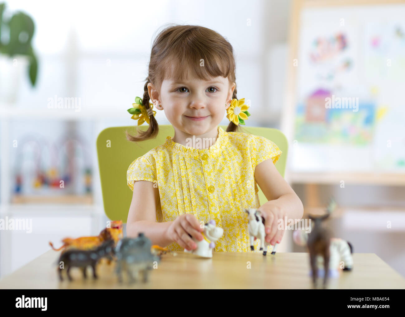 Petite fille jouant avec les jouets des animaux Banque D'Images
