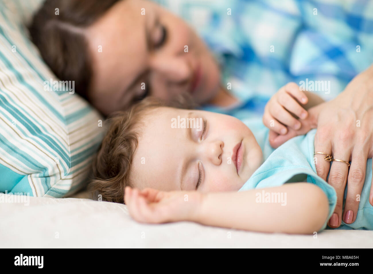 Mère et son fils bébé dormir ensemble dans une chambre à coucher Banque D'Images