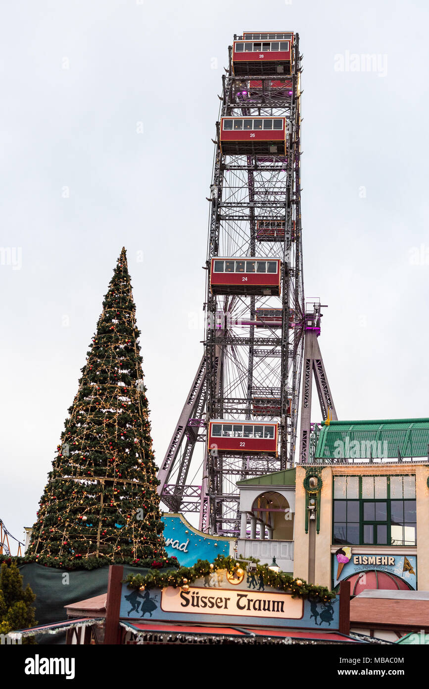 Vue de côté de la Wiener Riesenrad grande roue, parc d'attractions Prater, sur la gauche de l'arbre de Noël décoré Banque D'Images