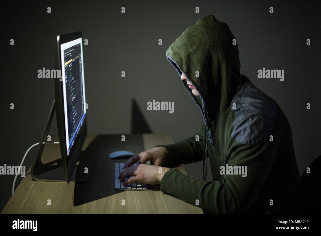 Un hacker dans un capot, sur un fond sombre hacking des réseaux informatiques Banque D'Images
