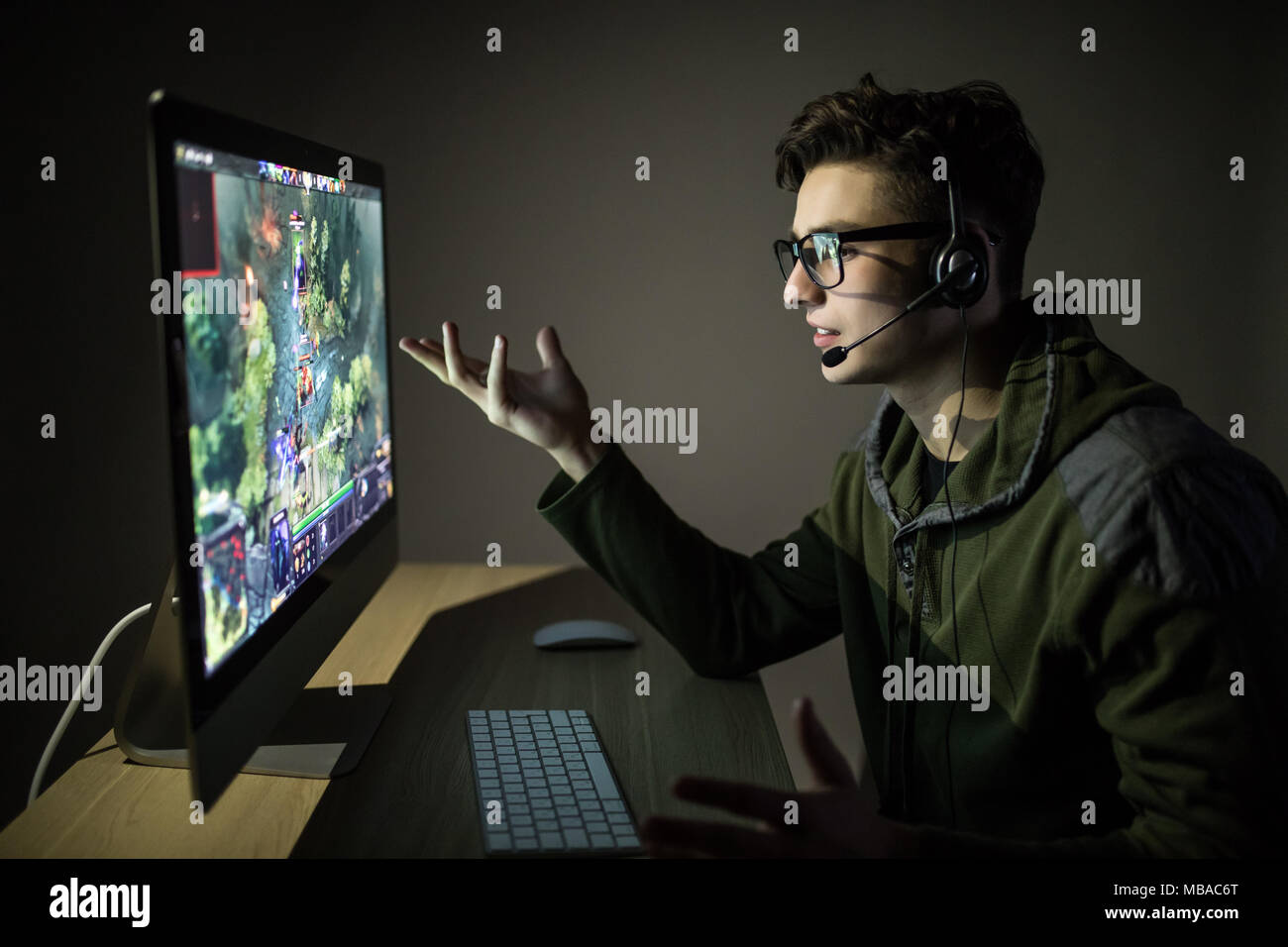 Jeune gameuse de casques et de lunettes à l'aide de la console et  l'ordinateur pour jouer au jeu dans la nuit Photo Stock - Alamy