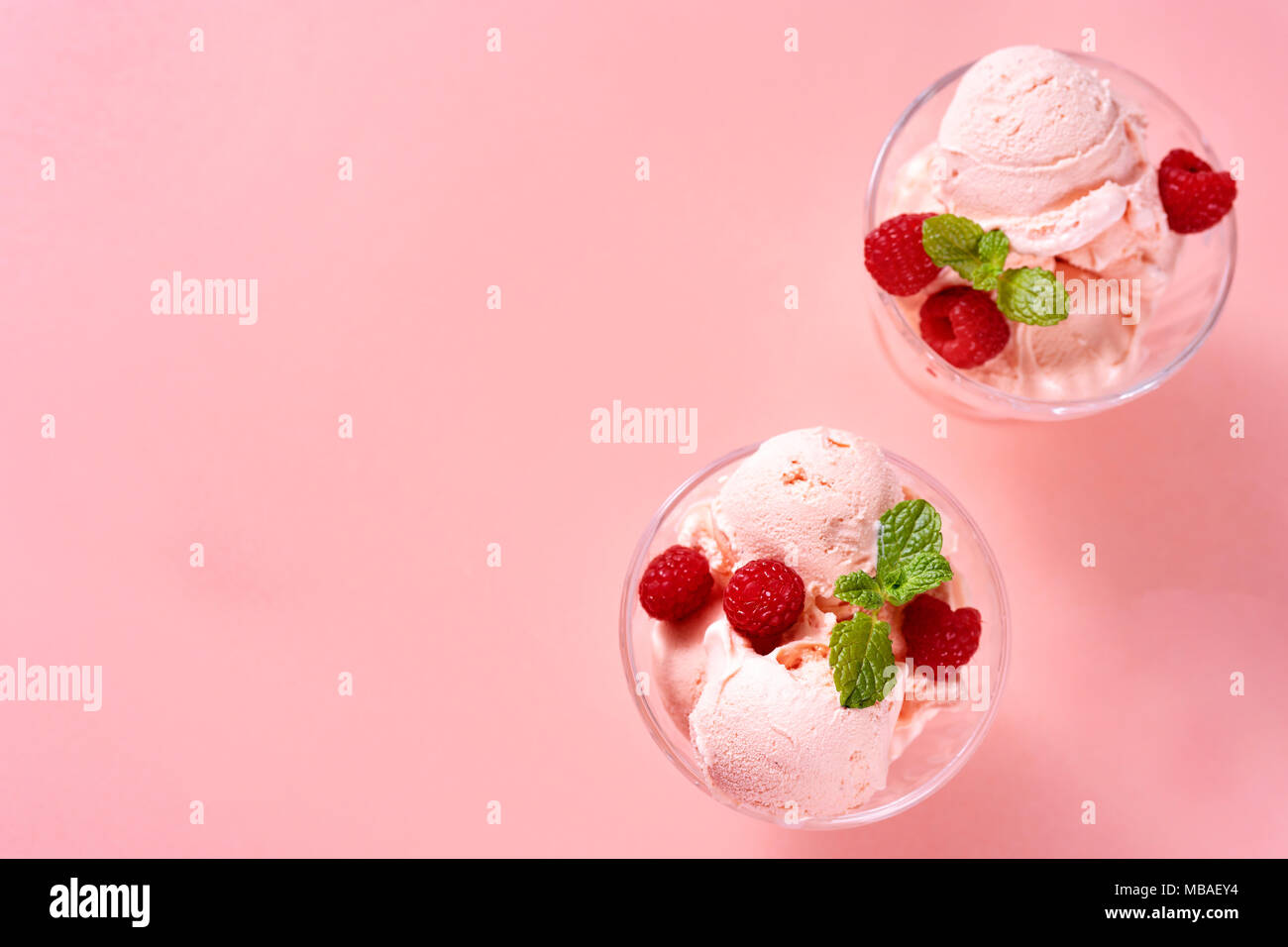 Vue de dessus de la crème glacée framboise billes en verre plats sur fond rose Banque D'Images