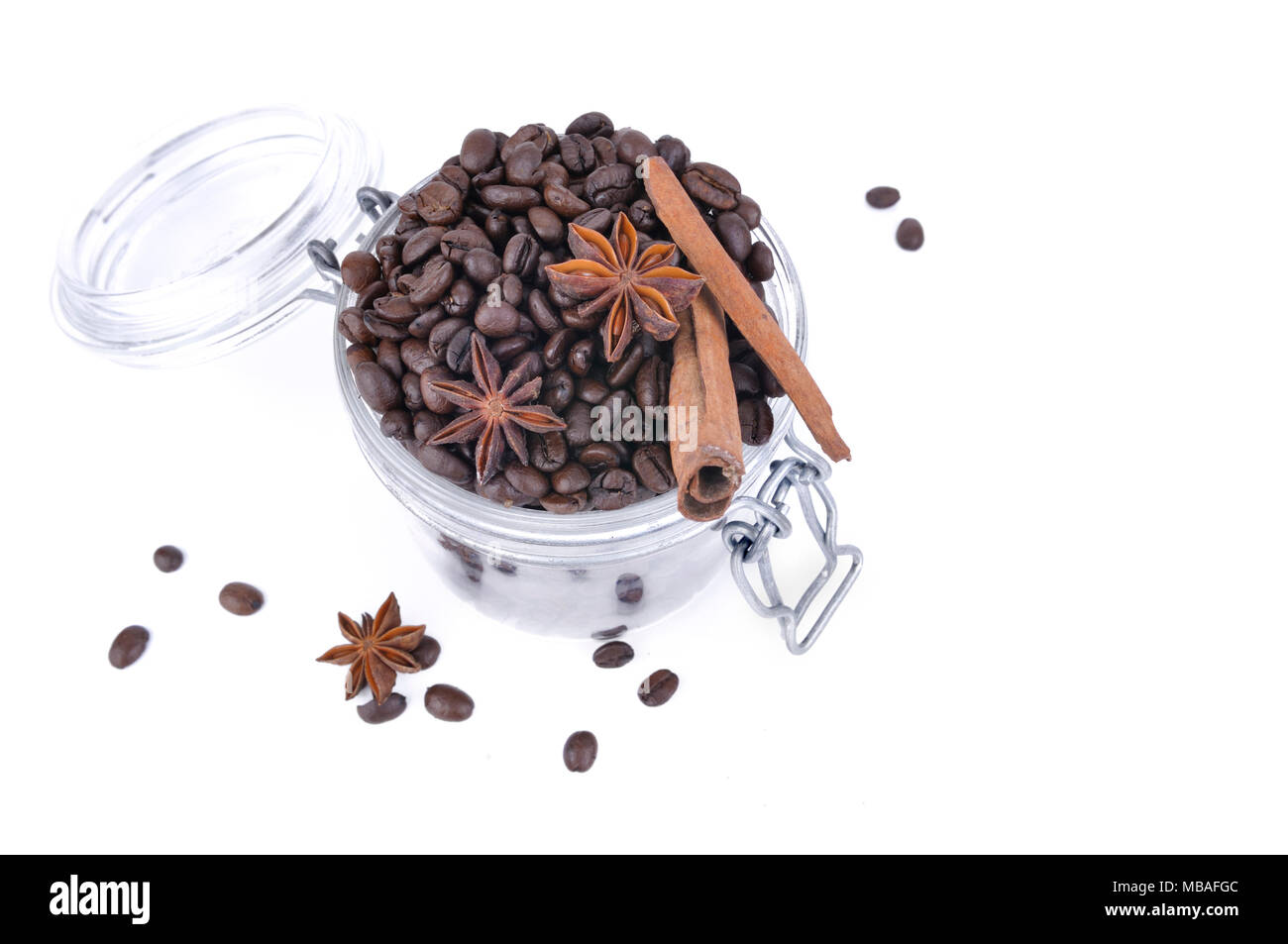 Vue de dessus sur l'anis et la cannelle dans les fèves de café dans un bocal en verre sur fond blanc Banque D'Images