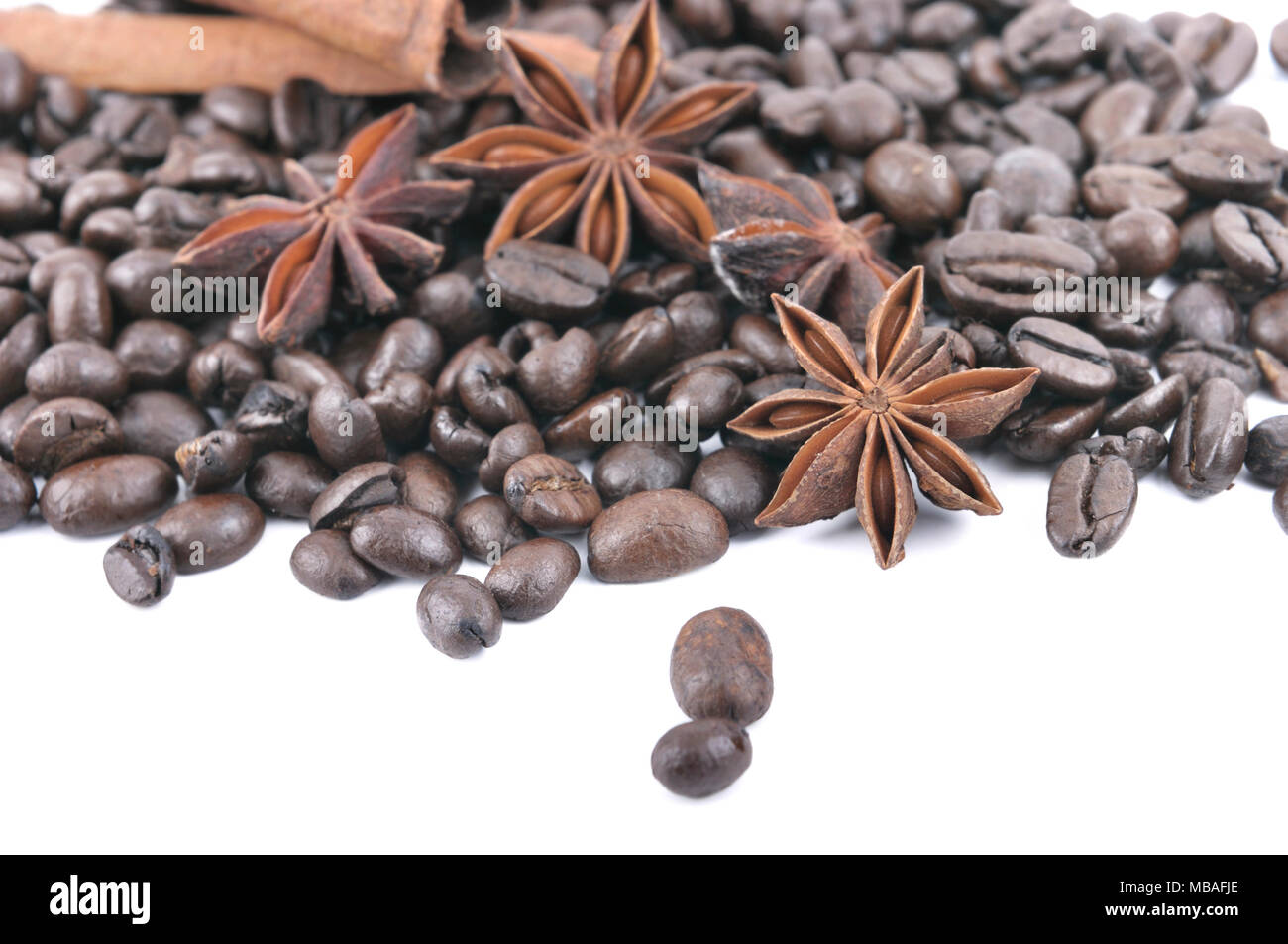 L'anis et la cannelle dans les fèves de café tas sur fond blanc Banque D'Images