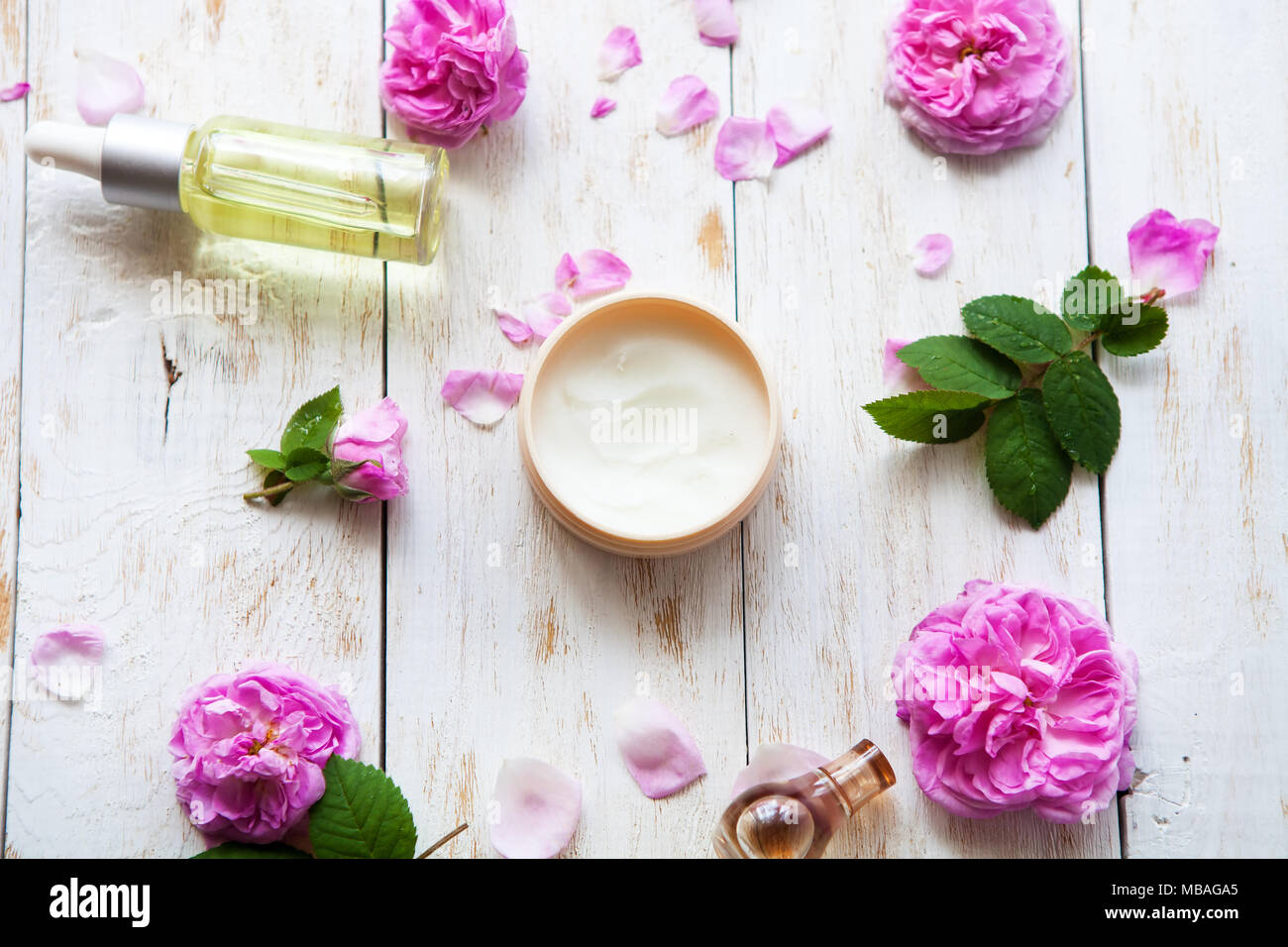 Crèmes cosmétiques et essence de rose l'huile avec des pétales de rose sur fond blanc d'un soin Spa. Spa Massage .vue supérieure mise à plat Banque D'Images