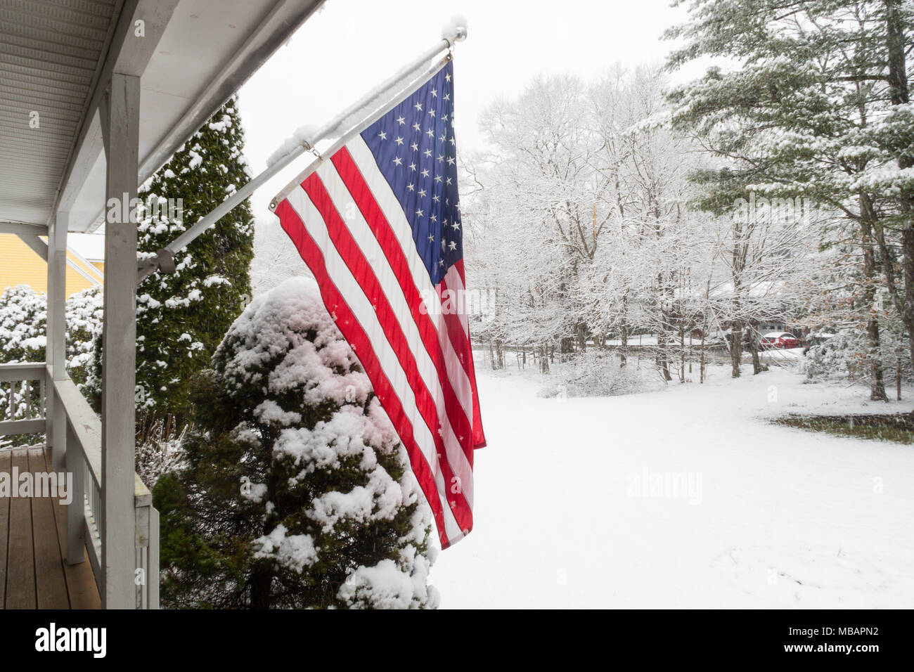Banlieue de luxe Accueil vole un drapeau américain dans une tempête de neige, la Nouvelle Angleterre, USA Banque D'Images