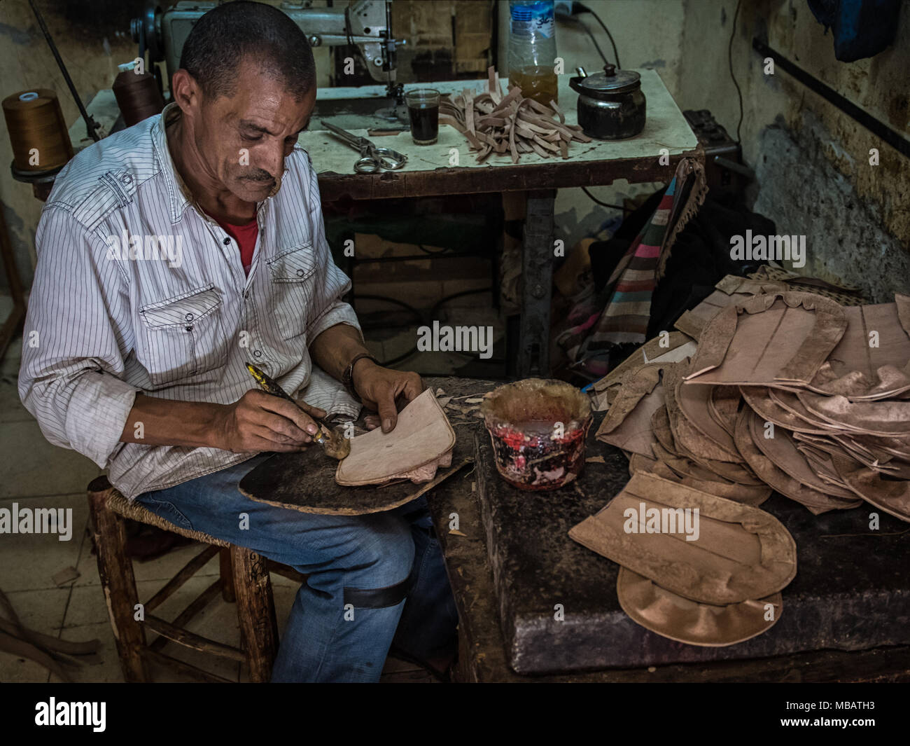 Un homme fait les semelles de chaussures en cuir dans le cuir de district de Marrakech. Banque D'Images