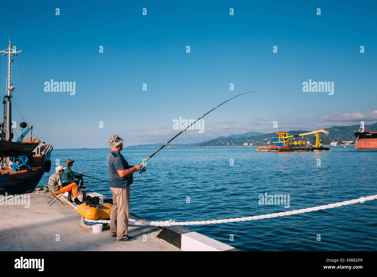 Batumi, Géorgie, l'Adjarie - 10 septembre 2017 : Vieil Homme près de Port de pêche quai sur soirée ensoleillée à l'heure du coucher du soleil à Batumi, Géorgie, l'Adjarie Banque D'Images