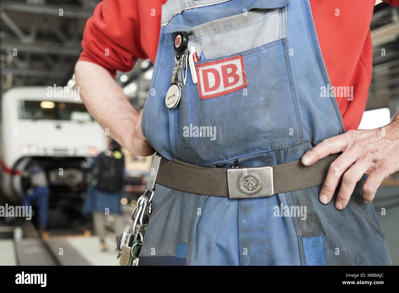 10 avril 2018, Allemagne, Berlin : Un employé de l'usine de fabrication de glace Rummelsburg porte une ceinture de la RDA's National armée du peuple. Photo : Jörg Carstensen/dpa Banque D'Images