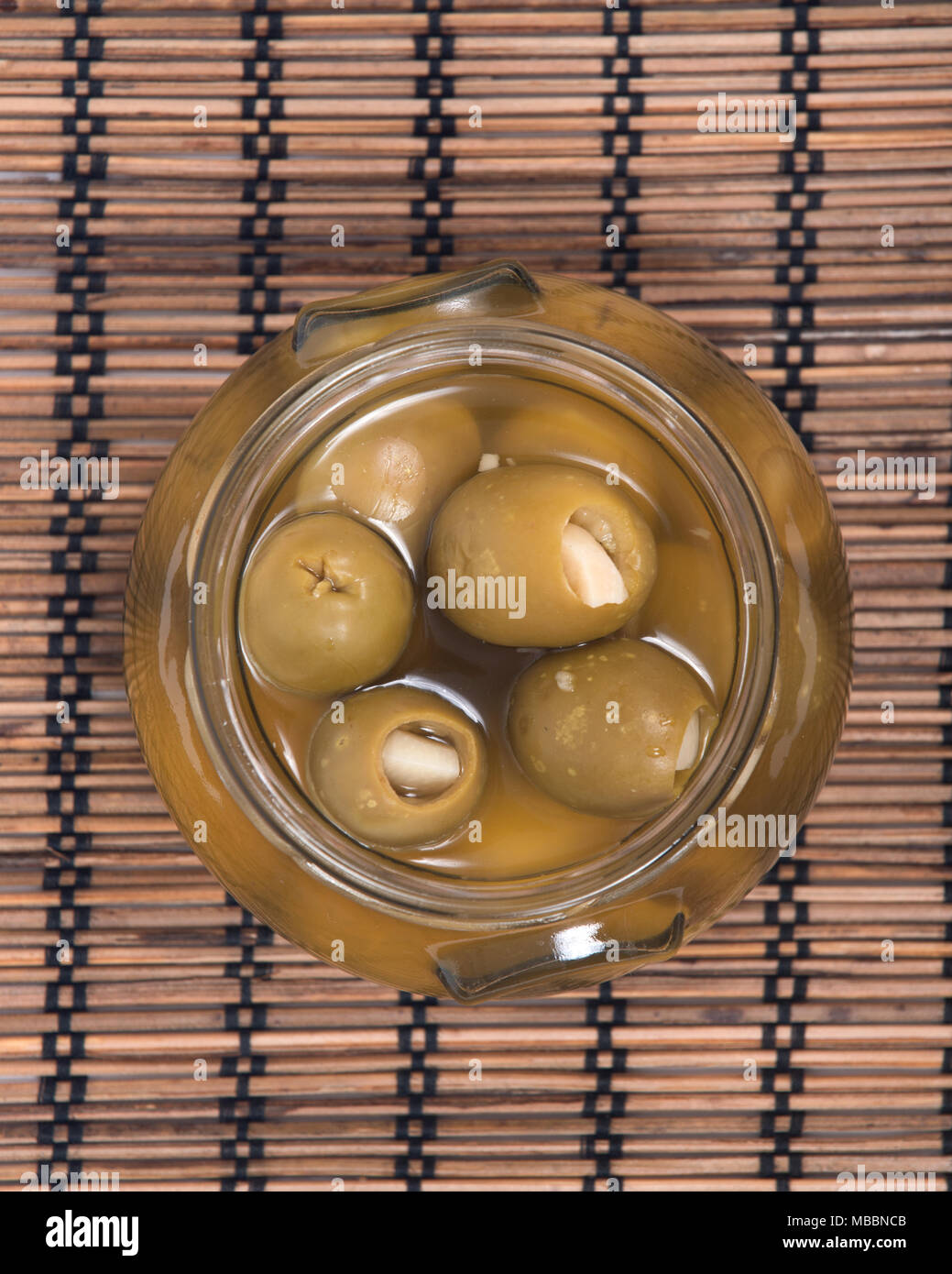 Main verte olives colossales farcies à l'gants in jar Banque D'Images
