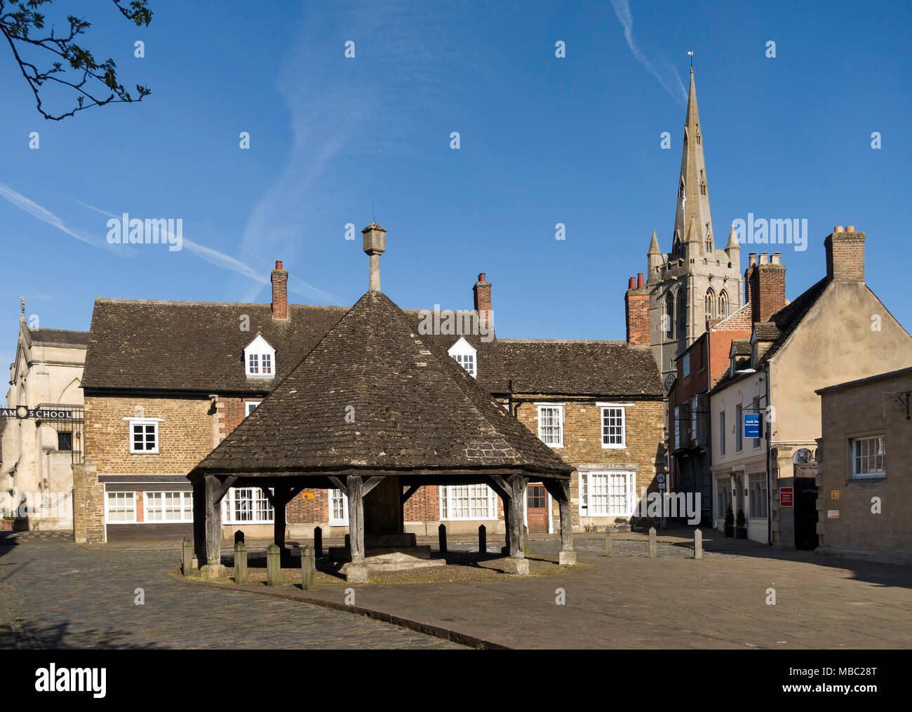 La vieille croix de beurre, Oakham bâtiments scolaires et tour de l'église All Saints vu de la place du marché, Oakham, Rutland, England, UK. Banque D'Images