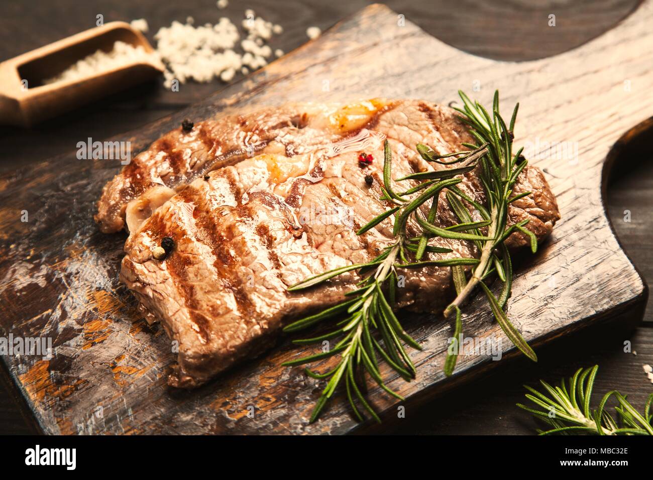 Le steak grillé sur planche à découper en bois Banque D'Images