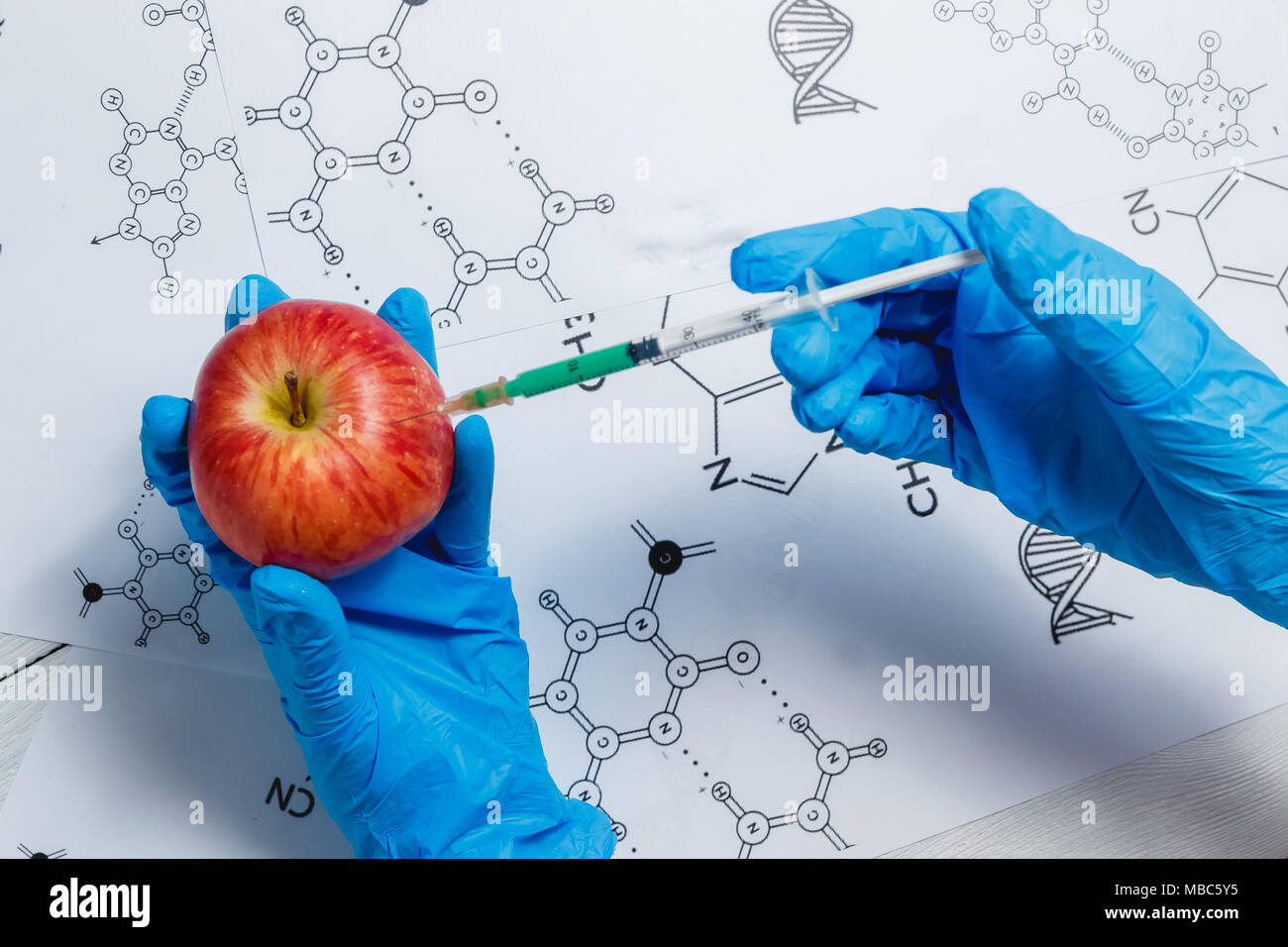 L'injection de liquide vert scientifique OGM à partir de la seringue dans Apple - Genetically Modified Food Concept Banque D'Images