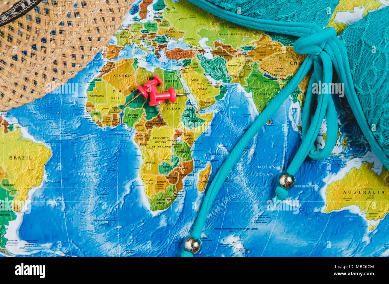 Les points de destination de voyage sur la carte du monde a indiqué avec des punaises, ruban rouge et faible profondeur de champ. Banque D'Images