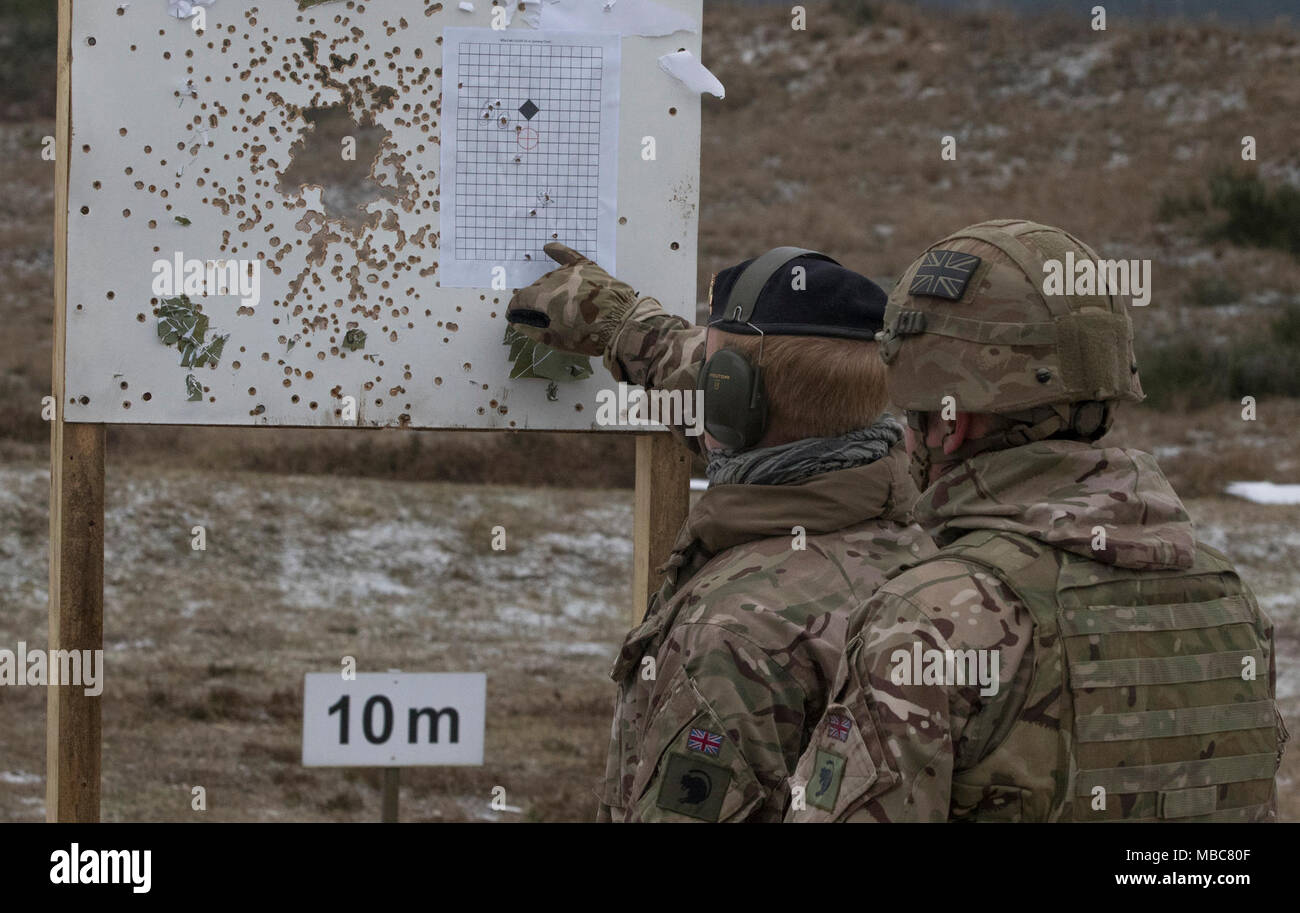 Soldats britanniques avec le Light Dragoons vérifier leur placement de groupe sur leur cible après avoir tiré leurs 5,56 millimètres de mitrailleuses légères à une plage près de la zone d'entraînement Bemowo Piskie, Pologne, le 15 février 2018. Ces soldats sont une partie de l'unique groupe de combat multinationales, composé de États-Unis, Royaume-Uni, croate et soldats roumains qui servent avec la 15e Brigade mécanisée polonaise comme une force de dissuasion dans le nord-est de la Pologne à l'appui de l'OTAN vers l'amélioration de la présence. (U.S. Army Banque D'Images