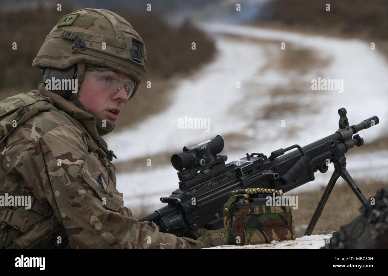 Un soldat britannique avec le Light Dragoons attend de recevoir des directives, comme il se prépare à ses feux 5,56 millimètres-light machine gun à une gamme près de la zone d'entraînement Bemowo Piskie, Pologne, le 15 février 2018. Ce soldat est une partie de l'unique groupe de combat multinationales, composé de États-Unis, Royaume-Uni, croate et soldats roumains qui servent avec la 15e Brigade mécanisée polonaise comme une force de dissuasion dans le nord-est de la Pologne à l'appui de l'OTAN vers l'amélioration de la présence. (U.S. Army Banque D'Images