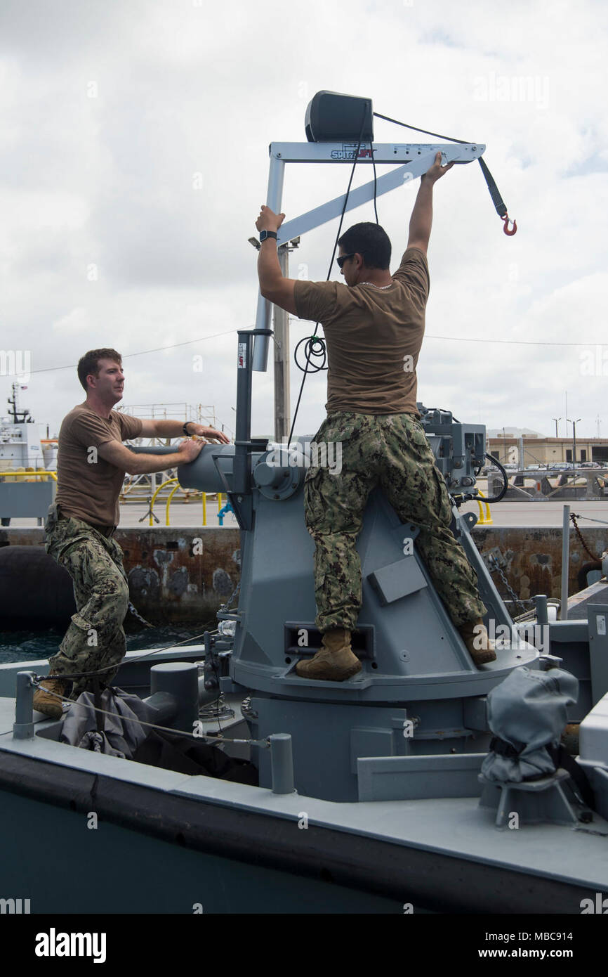 Technicien électronique 1re classe Ryan Christian et chef de Gunner's Mate John Zuniga, toutes deux affectées aux zones côtières Groupe fluviales (CRG) 1 Det. Guam, monter une grue mobile sur une patrouille Mark VI au cours des opérations de routine pendant les escales de croisières Naval Base de Guam, le 15 février 2018. CRG-1 Det. Guam est attribué au commandant, Force opérationnelle 75, la task force expéditionnaire principale responsable de la planification et l'exécution des opérations fluviales côtières, des explosifs et munitions, d'ingénierie et de construction, plongée sous-marine et de construction dans la 7e flotte américaine zone d'opérations. (U.S. La lutte contre la marine C Banque D'Images