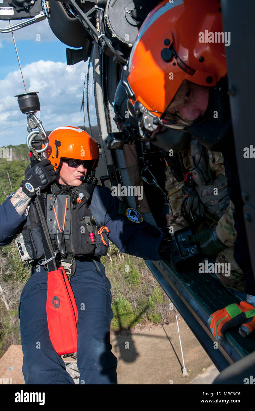 Ben Dye, un nageur de sauvetage avec l'hélicoptère de la Caroline du Sud, l'équipe de sauvetage aquatique est abaissé d'une garde nationale de Caroline du Sud UH-60 Black Hawk lors de l'exécution des opérations de sauvetage sur le toit pendant l'Exercice PATRIOT 18 sud au camp Shelby, Mississippi le 15 février 2018. PATRIOT Sud est une agence, les opérations de l'exercice, l'accent sur la préparation aux catastrophes naturelles et comprend la Garde nationale et les unités de premiers intervenants civils de partout au pays. (Ohio Air National Guard Banque D'Images