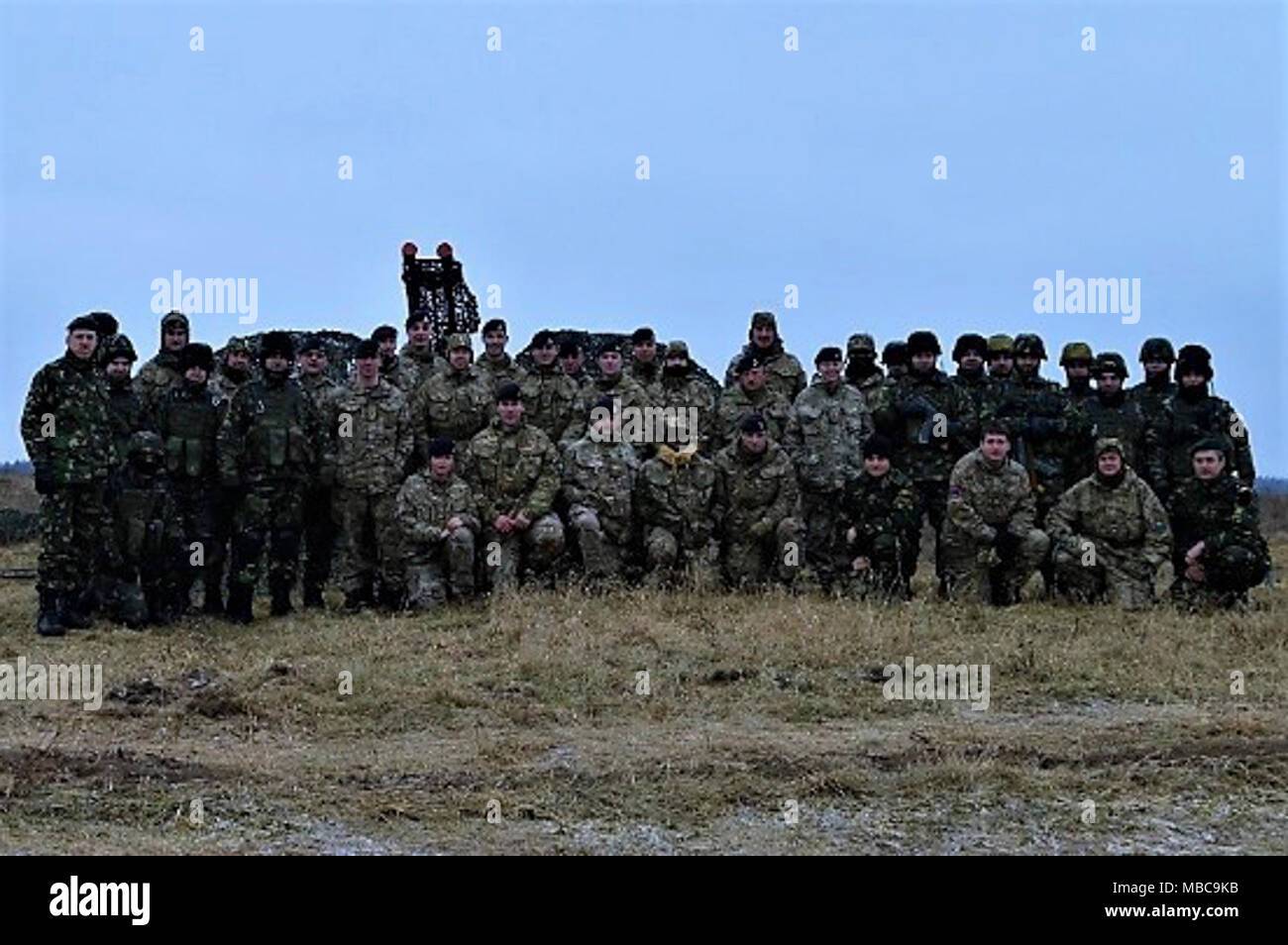 Soldats roumains de la masse de l'armée de défense aérienne de la base "Détachement de chauves-souris noire" attribué à la Pologne et Royaume-Uni Groupe de combat des soldats affectés à un groupe de combat Estonie posent ensemble après avoir mené des formations de défense aérienne près de Bemowo Piskie Domaine de formation, la Pologne, le 16 février 2018. La Pologne est un groupe de combat, l'unique groupe de combat multinationales est composé de États-Unis, Royaume-Uni, croate et soldats roumains qui servent avec la 15e Brigade mécanisée polonaise comme une force de dissuasion dans le nord-est de la Pologne à l'appui de l'OTAN vers l'amélioration de la présence. Banque D'Images