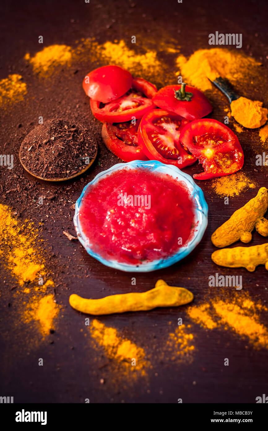 Close up de purée de tomates, le curcuma et son bois de santal,poudre sur une surface en bois.Il est utilisé pour effacer les têtes sombres et la peau noire. Banque D'Images