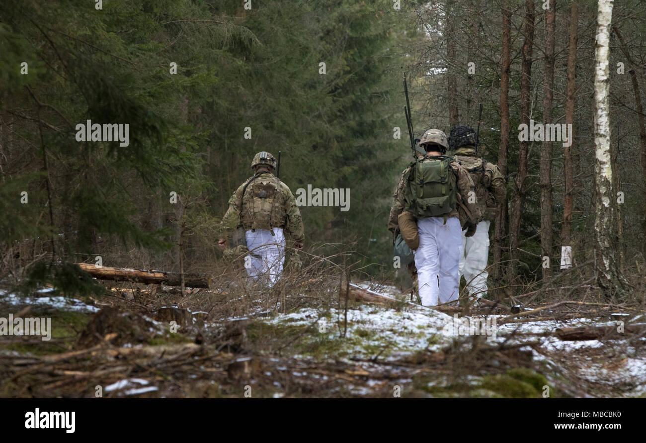 Des soldats américains affectés à la Troupe de fer, 3e Escadron, 2e régiment de cavalerie, ruck à travers la forêt polonaise pour trouver et mettre en place des positions défensives tout en participant à l'exercice de formation de multinationales à Puma une gamme près de la zone d'entraînement Bemowo Piskie, Pologne, le 19 février, 2018. Ces soldats font partie de l'unique, composé de groupe de combat multinationales des États-Unis, du Royaume-Uni, de la Croatie et de soldats roumains qui servent avec la 15e Brigade mécanisée polonaise comme une force de dissuasion dans le nord-est de la Pologne à l'appui de l'OTAN vers l'amélioration de la présence. (U.S. Army Banque D'Images