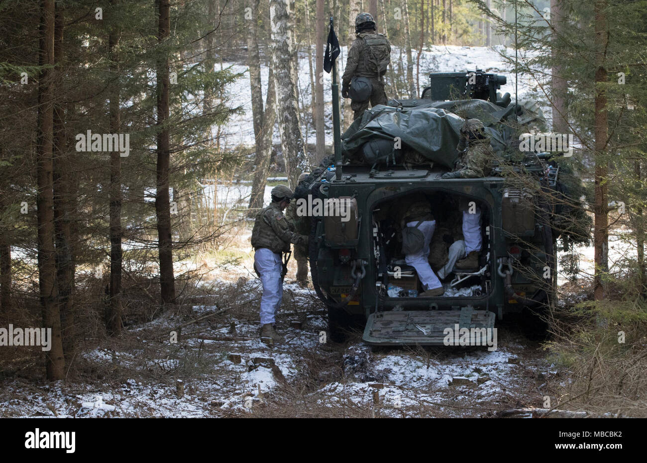 Des soldats américains affectés à la Troupe de fer, 3e Escadron, 2e régiment de cavalerie, démonter leur Stryker pour aller et établir leur position défensive tout en participant à l'exercice de formation de multinationales à Puma une gamme près de la zone d'entraînement Bemowo Piskie, Pologne, le 19 février, 2018. Ces soldats font partie de l'unique, composé de groupe de combat multinationales des États-Unis, du Royaume-Uni, de la Croatie et de soldats roumains qui servent avec la 15e Brigade mécanisée polonaise comme une force de dissuasion dans le nord-est de la Pologne à l'appui de l'OTAN vers l'amélioration de la présence. (U.S. Army Banque D'Images