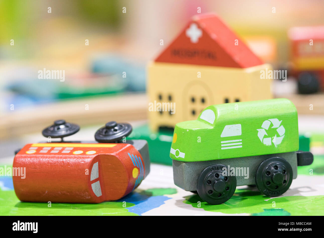 Jouet en bois deux trains sur route avec en toile de fond de l'hôpital (l'accent sélective) Jouets pour enfants Aire de jeux couverte Banque D'Images