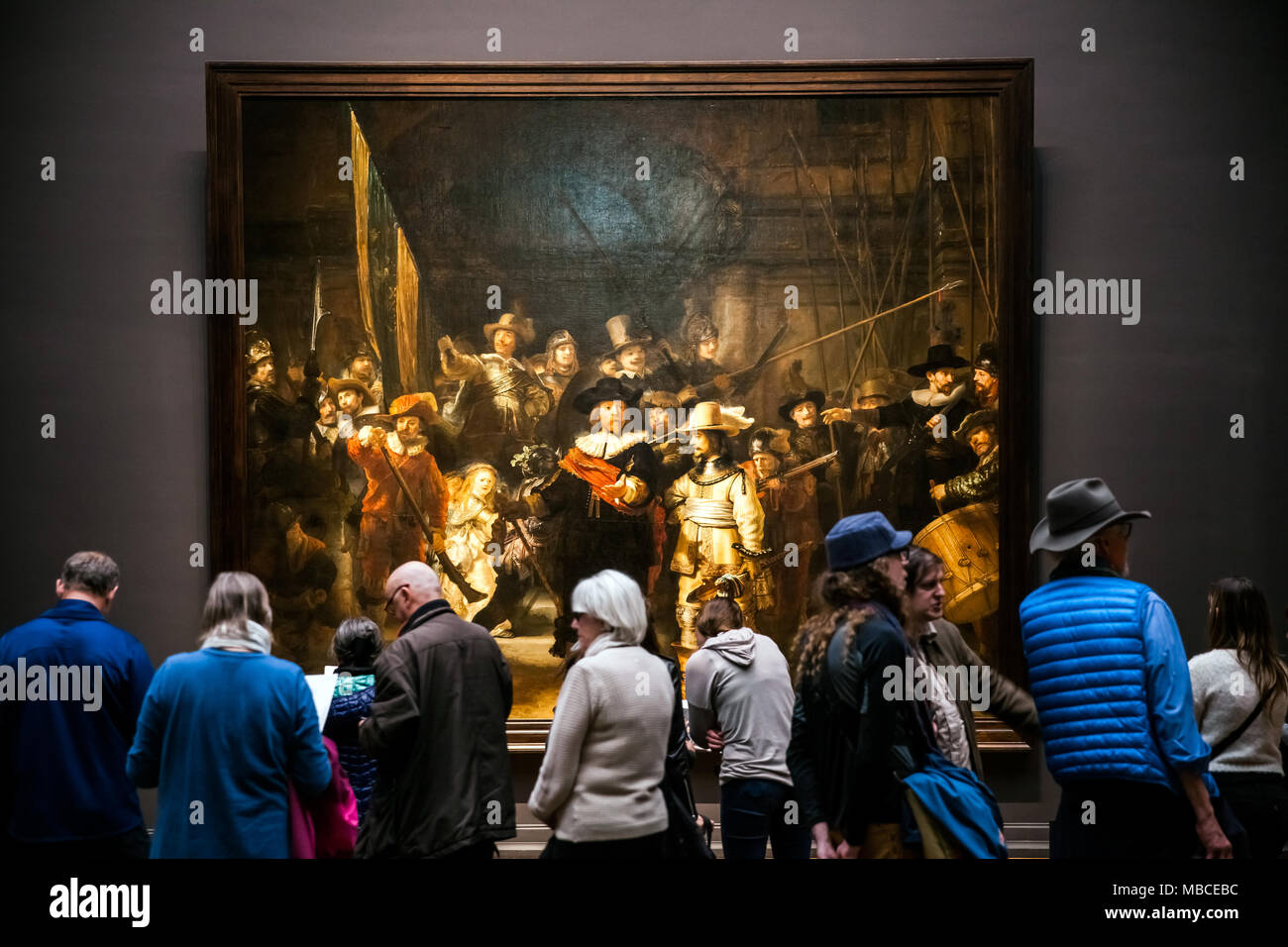Visiteurs regardant la Ronde de nuit de Rembrandt, plus grand et le