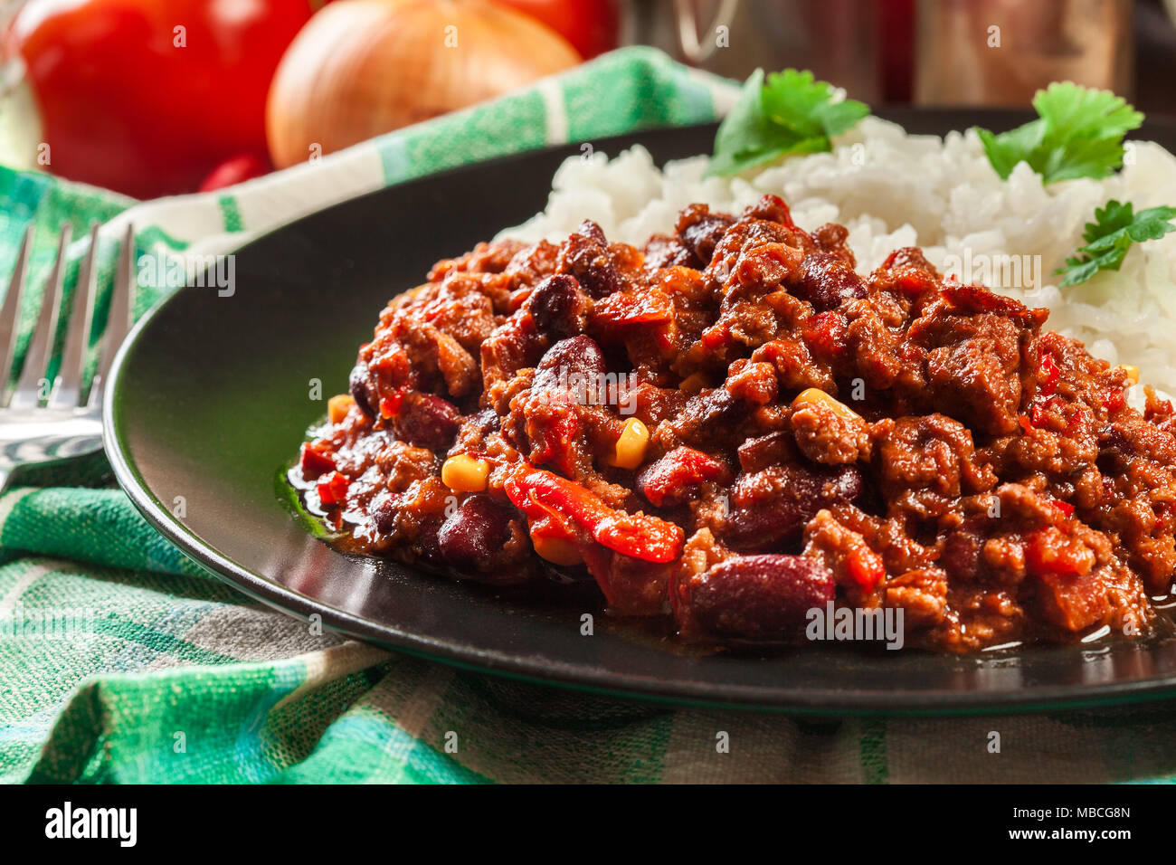 Hot chili con carne avec du boeuf haché, haricots, tomates et de maïs servi avec du riz. La cuisine mexicaine Banque D'Images