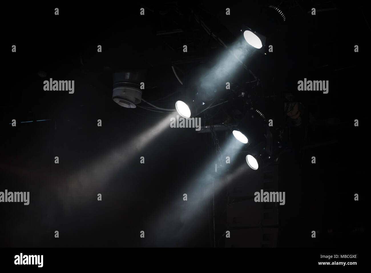 Groupe des projecteurs avec des poutres apparentes en fumée sur fond sombre, stade moderne d'équipement d'éclairage Banque D'Images