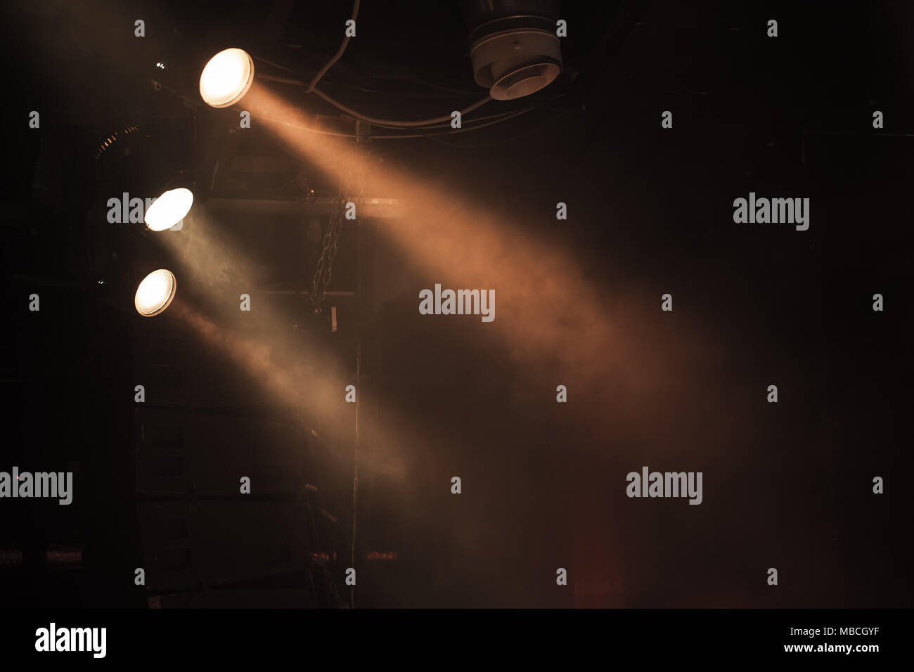 Trois projecteurs avec des poutres apparentes en fumée sur fond sombre, stade moderne d'équipement d'éclairage Banque D'Images