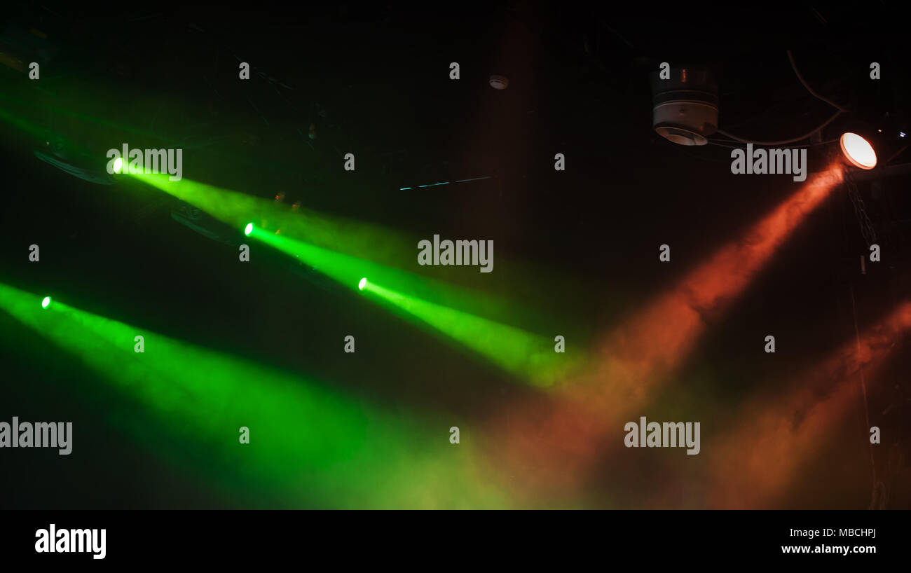 Endroit pittoresque rouge et vert avec des feux de solides poutres apparentes dans la fumée sur fond sombre, stade moderne d'équipement d'éclairage Banque D'Images