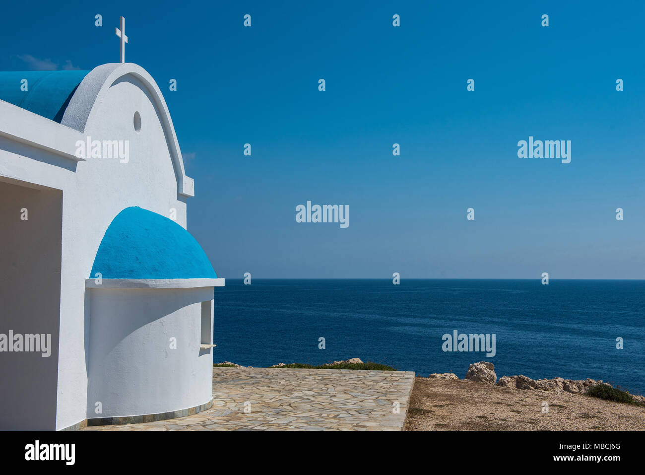 Église blanchie à la chaux avec toit bleu près de la mer. Chapelle d'Agioi Anargyroi, Chypre Banque D'Images