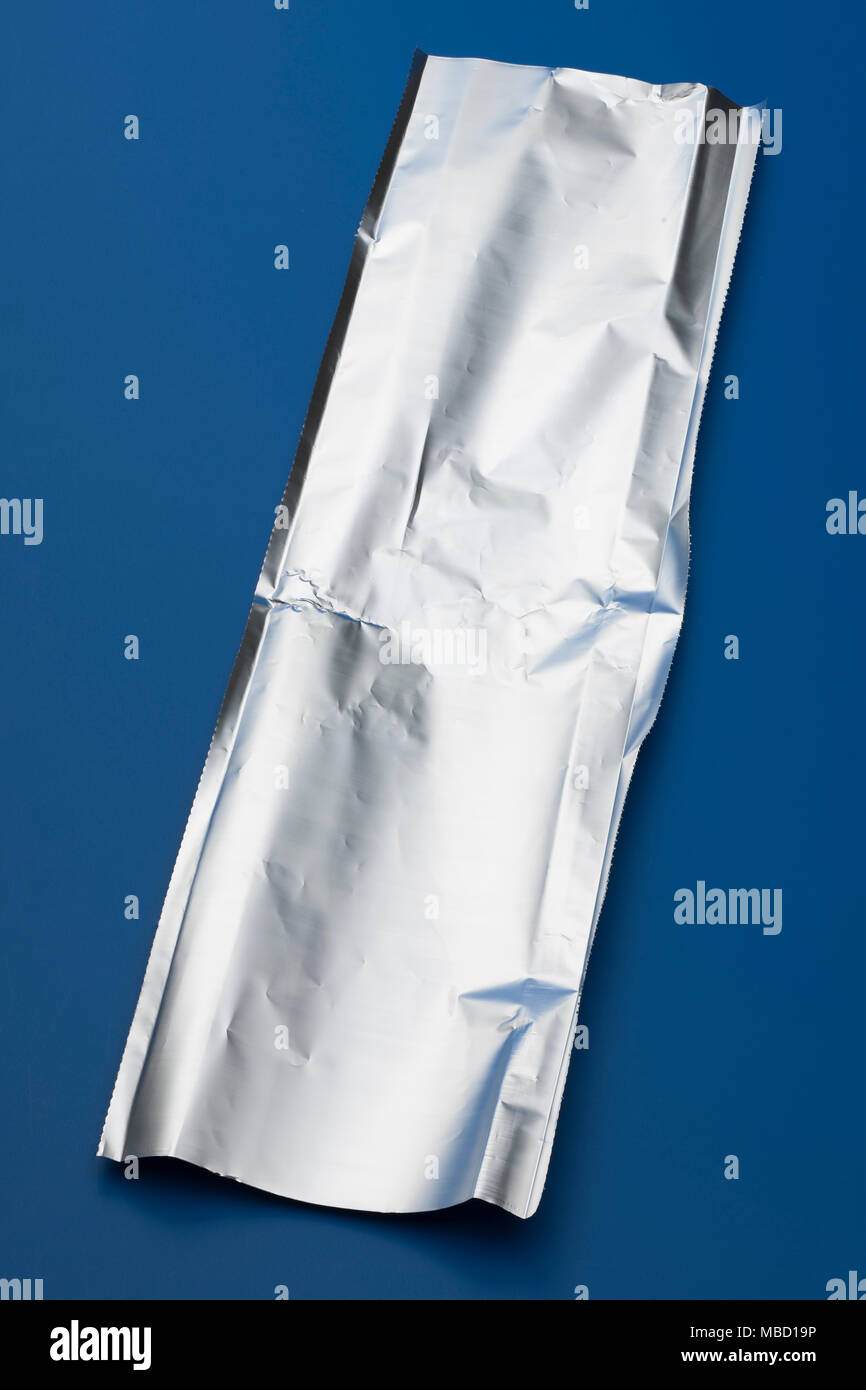 Morceau de papier aluminium de cuisine sur un fond bleu Banque D'Images