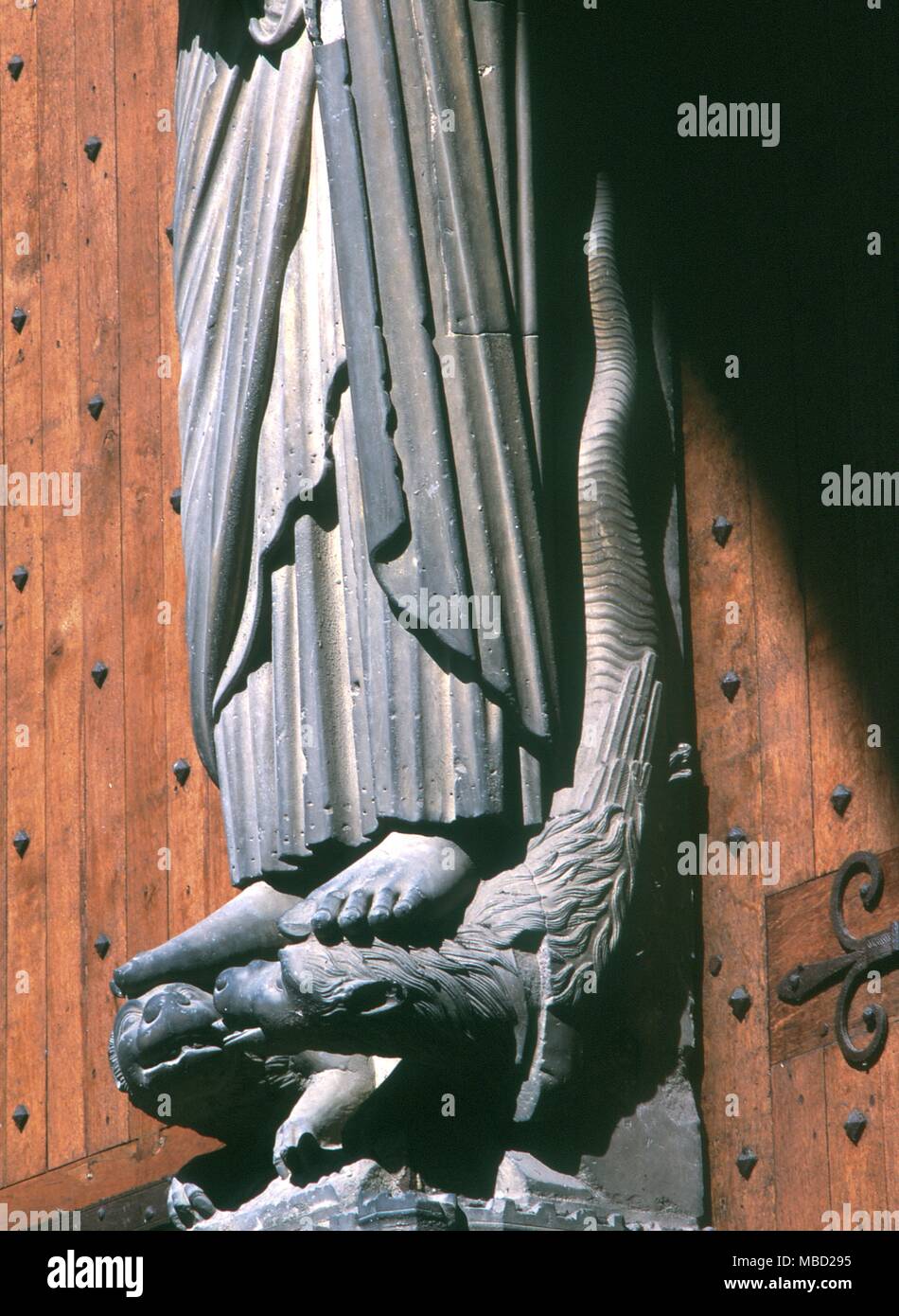 Magie de la lumière. La figure du Christ sur le portail sud de la cathédrale de Chartres. Le serpent (démon païen de l'obscurité, Ahriman) étant inondé de soleil en même temps que le livre de vie. Banque D'Images