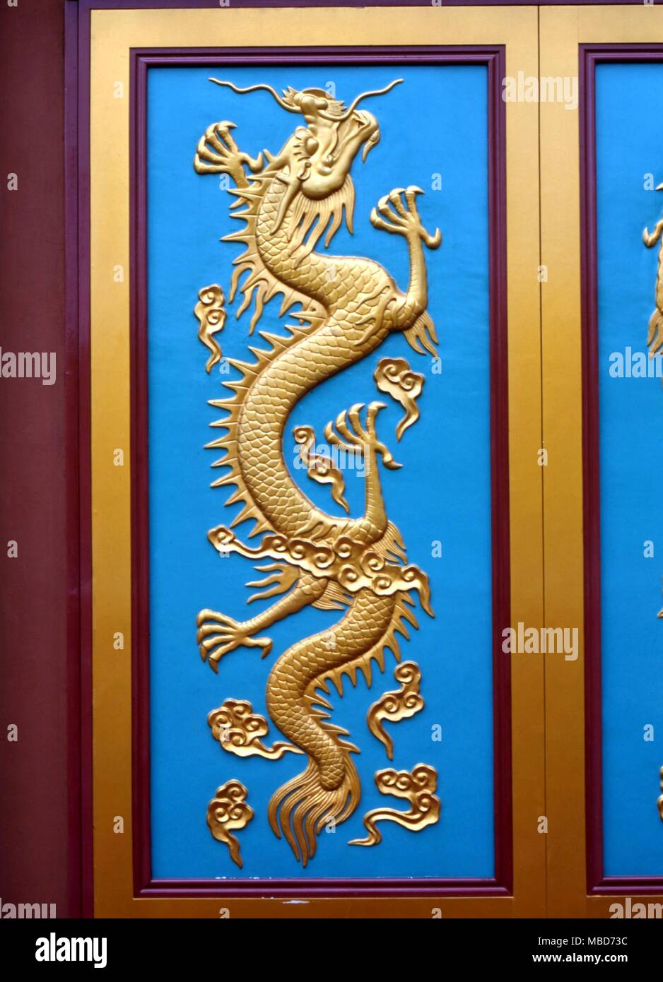 Dragon sur un fond bleu. Panneau de porte bas-relief dans les motifs de la Haw Par Villa Park, Singapore Banque D'Images