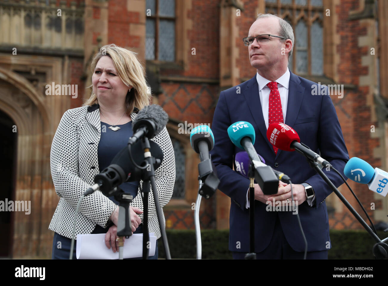 L'Irlande du Nord Secrétaire Karen Bradley et le ministre irlandais des affaires étrangères Simon Coveney parler aux médias lors d'un événement pour marquer le 20e anniversaire de l'Accord du Vendredi Saint, à l'Université Queen's de Belfast. Banque D'Images