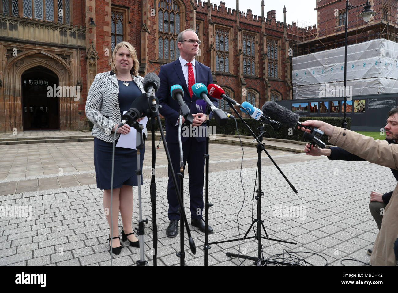 L'Irlande du Nord Secrétaire Karen Bradley et le ministre irlandais des affaires étrangères Simon Coveney parler aux médias lors d'un événement pour marquer le 20e anniversaire de l'Accord du Vendredi Saint, à l'Université Queen's de Belfast. Banque D'Images