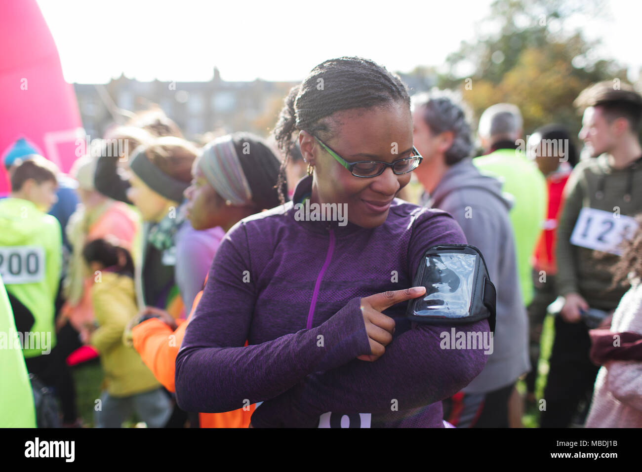 Coureuse de la préparation de la musique sur un lecteur mp3 Bande de bras de charity run Banque D'Images