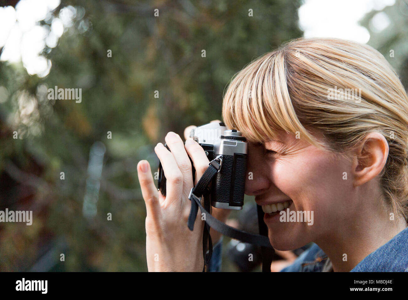 Smiling woman using camera Banque D'Images