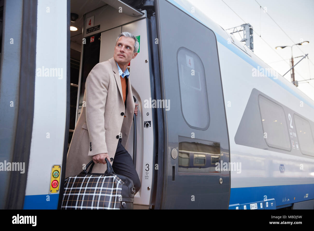 Businessman getting off train passager Banque D'Images