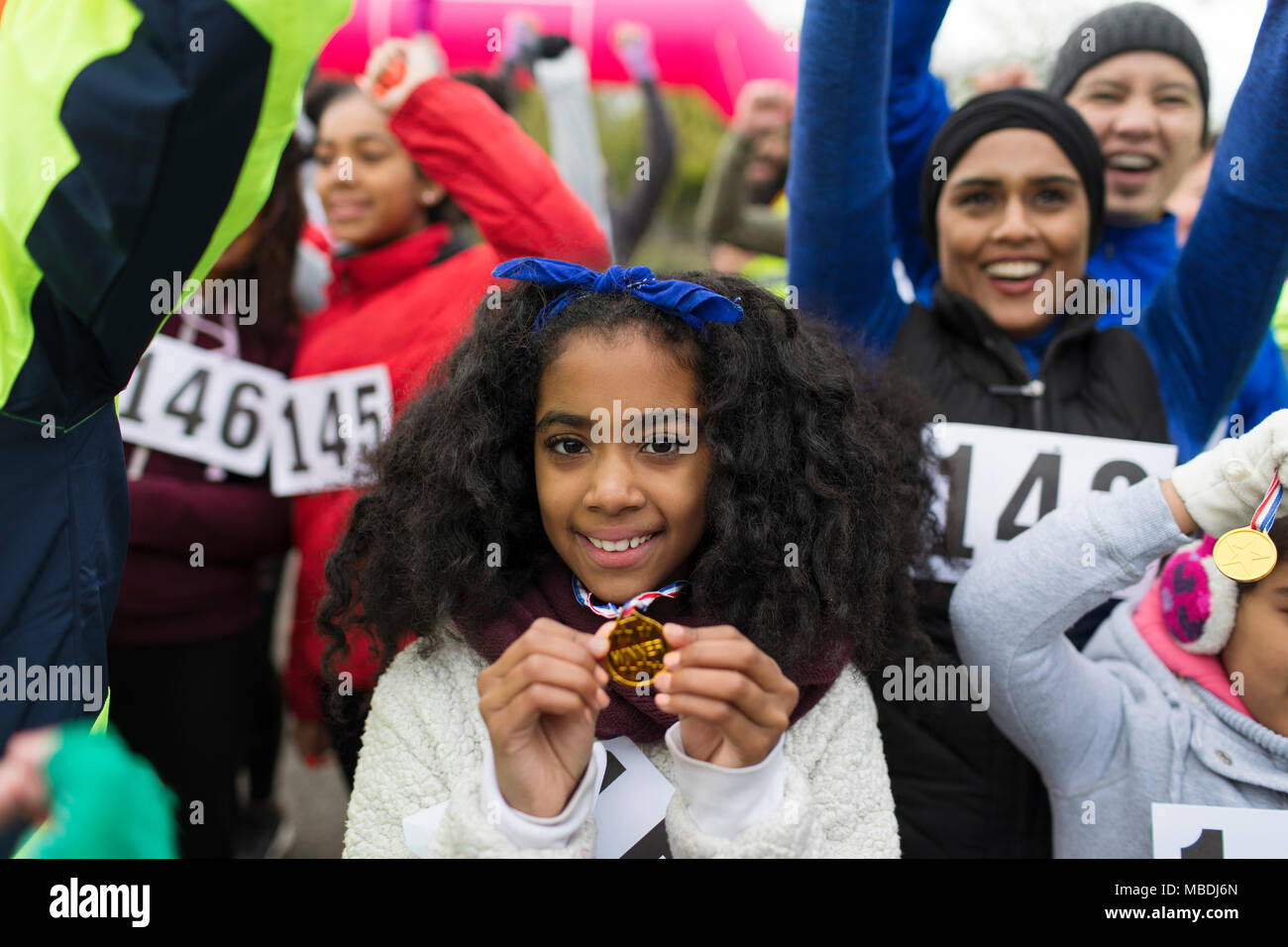 Portrait of smiling girl runner montrant médaille à la charité s'exécuter dans park Banque D'Images