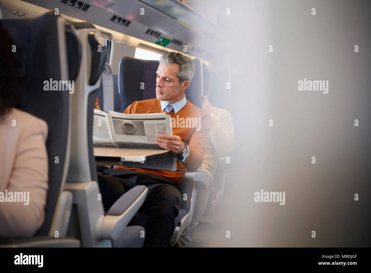 Businessman reading newspaper on train de passagers Banque D'Images