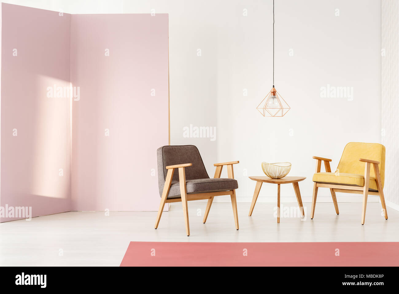 Salon féminin intérieur avec des murs pastel, fauteuils et table basse vintage Banque D'Images